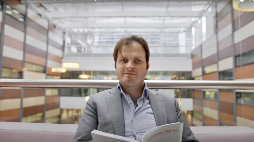 Portretfoto van Tijs van den Broek met een boek in zijn handen